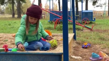 Küçük sevimli kız bebek oyun parkında oynuyor..