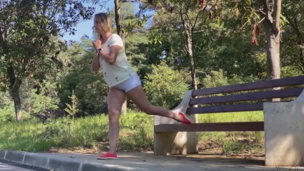 Giovane donna sottile attraente fare ginnastica nel parco . — Video Stock