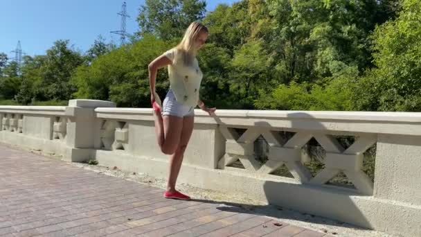 Mladá atraktivní štíhlá žena, která se táhne do parku. Koncepce zdravého životního stylu — Stock video