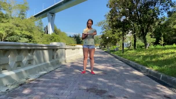 Donna sportiva che corre nel parco della città indossando Smartwatch — Video Stock