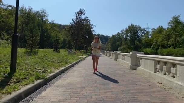 Sportlerin läuft mit Smartwatch im Stadtpark — Stockvideo