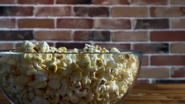 Popcorn dans un bol en verre sur fond en bois — Video