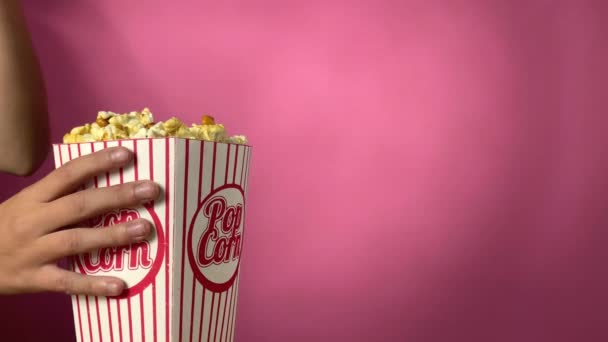 Meisje houdt popcorn vast en eet het op. — Stockvideo