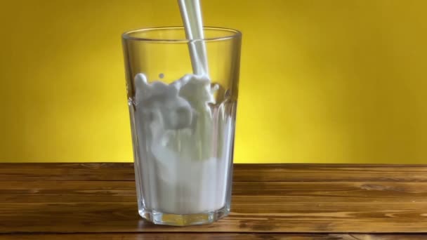 Verser le lait de la cruche au verre sur une table en bois rustique 