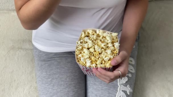 Señora comiendo palomitas de maíz mientras mira la pantalla de TV — Vídeos de Stock