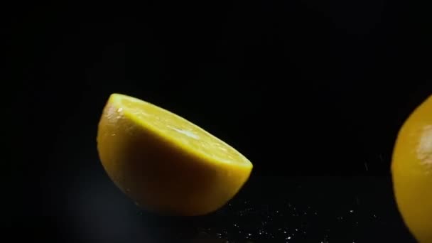 Naranjas en rodajas está cayendo amanecer sobre fondo negro, cámara lenta — Vídeo de stock