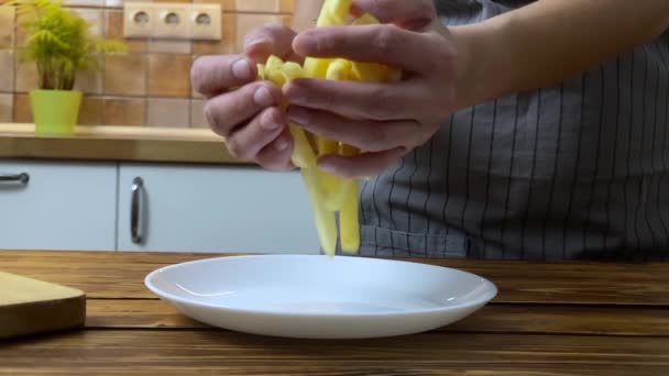 Las manos de una mujer poniendo papas fritas en el plato, cámara lenta — Vídeos de Stock