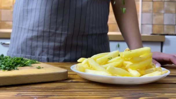 Une main de femme mettant du fenouil sur des frites, au ralenti — Video