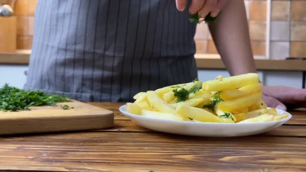 Uma mão de mulher colocando erva-doce em batatas fritas, câmera lenta — Vídeo de Stock