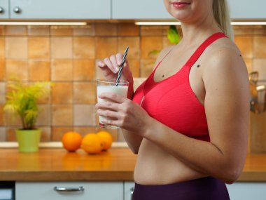 Kız mutfakta badem sütünden kokteyl içiyor, yavaş çekim videosu.