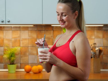 Kız mutfakta badem sütünden kokteyl içiyor, yavaş çekim videosu.