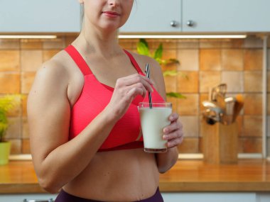 Kız mutfakta badem sütünden kokteyl içiyor, yavaş çekim videosu.