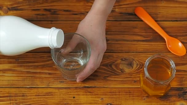 Sportovní dívka nalévá mandlové mléko do sklenice v kuchyni, zpomalený film — Stock video
