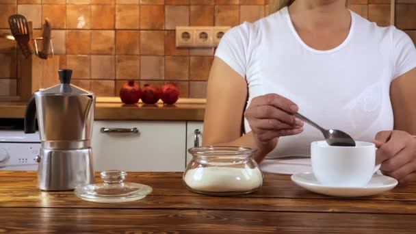 Girl holds a spoon and strews sugar to mug — Stock Video