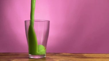 Yeşil detoks smoothie bardağa dökülüyor.