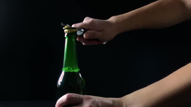 Női kéz egy üveg sörrel nyitott fekete háttér, lassított felvétel — Stock videók