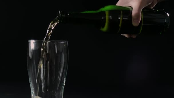 Bier in een glas gieten uit groene fles, slow motion — Stockvideo