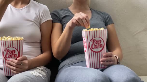 Glückliche Familienmutter mit kleiner Tochter vor dem Fernseher zusammen mit Popcorn — Stockvideo