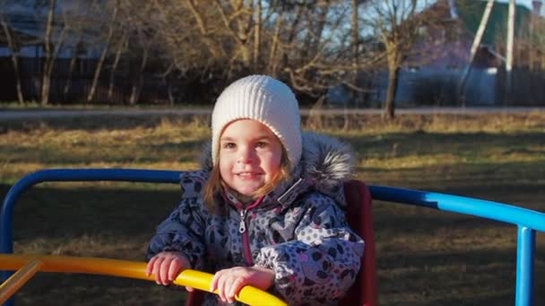 Chica montando en un columpio en el invierno en el patio de recreo, cámara lenta — Vídeos de Stock