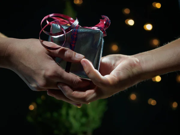 Un hombre le da a una mujer un regalo para Navidad —  Fotos de Stock