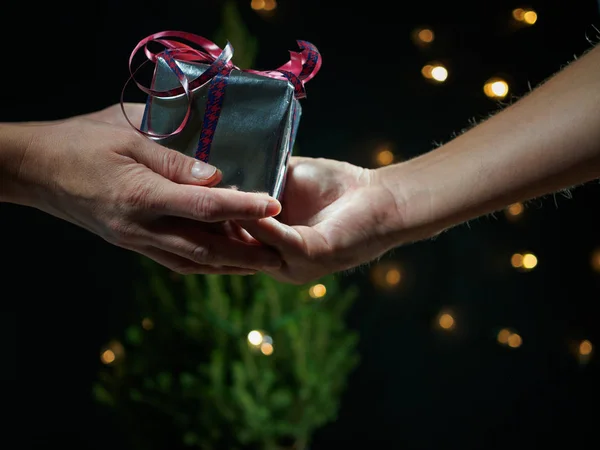 Un hombre le da a una mujer un regalo para Navidad — Foto de Stock