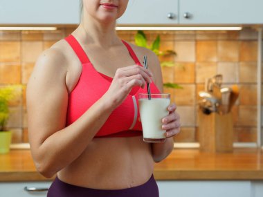 Kız mutfaktaki badem sütünden bir kokteyl içiyor.