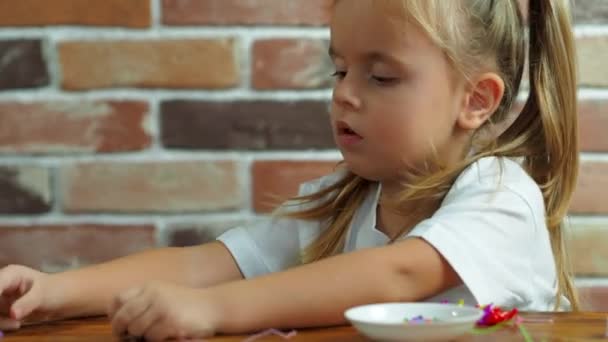 Cute little baby girl make a bracelet from beads — Stock Video