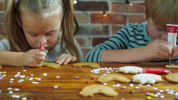 Niño y niña decoran galletas de Navidad para las vacaciones — Vídeo de stock