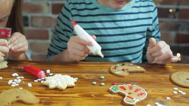 Crianças decoram biscoitos de gengibre para o feriado — Vídeo de Stock