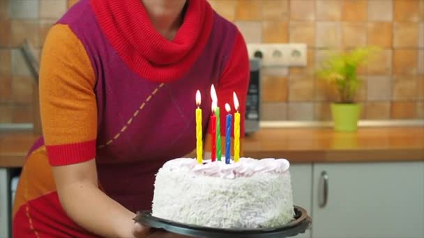 Crianças apagam velas em um bolo de aniversário, que mantém a mãe — Vídeo de Stock