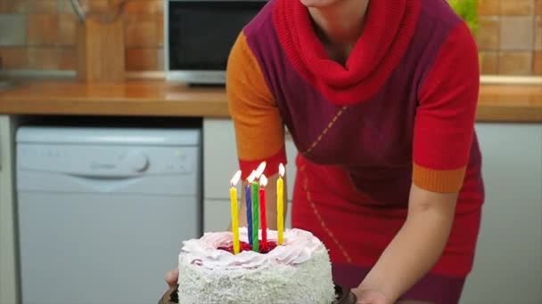 Děti sfouknou svíčky na narozeninový dort, který drží mámu — Stock video