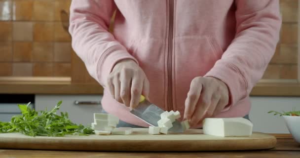 Mujer deportiva hacer ensalada saludable en la cocina de rukkola, tomate y queso — Vídeos de Stock