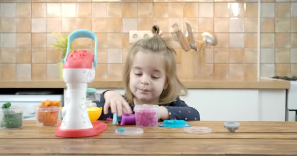 Klein baby meisje spelen met kleurrijk deeg — Stockvideo