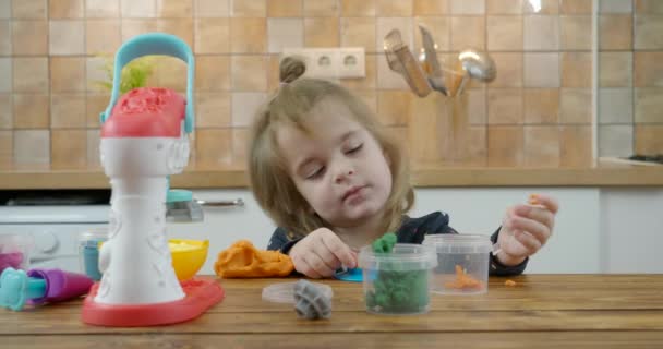 Little baby girl playing with colorful dough — Stock Video