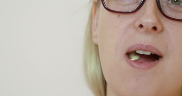 Vrouwengezicht in glazen die popcorn eten — Stockvideo
