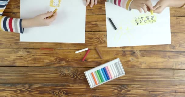 Niño y niña dibujando en pastel sobre papel, vista superior — Vídeo de stock