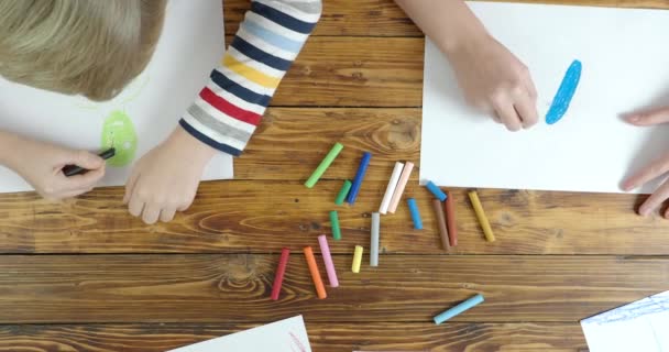 Dibujo de niño y niña en pastel sobre papel, vista superior — Vídeo de stock
