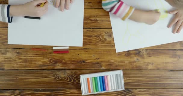 Niño y niña dibujando en pastel sobre papel, vista superior — Vídeos de Stock