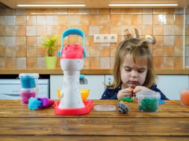 Küçük kız renkli hamurla oynuyor 