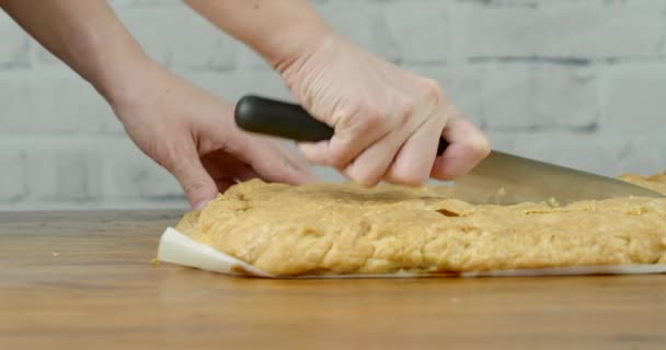 Женщина режет пирог ручной работы на столе — стоковое видео