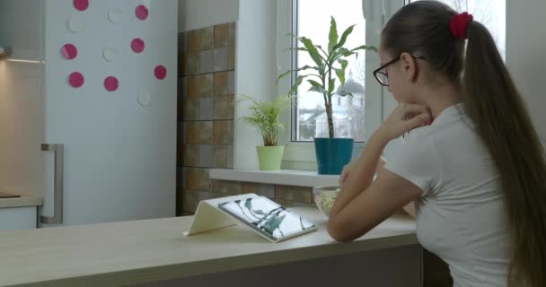 Tiener meisje op zoek serie op de tablet en het eten van popcorn — Stockvideo