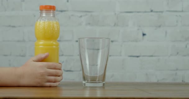 Jongenshanden houden fles met sinaasappelsap vast. — Stockvideo