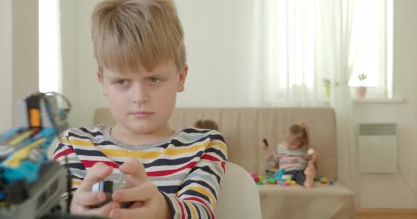 Μικρό αγόρι που δοκιμάζει ρομποτικά παιχνίδια στην τάξη — Αρχείο Βίντεο