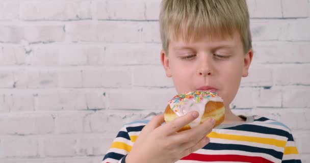 Kleiner lustiger Junge isst Kuchen vor der Kamera — Stockvideo