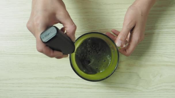 Vrouw die matcha thee maakt, gemengd water met matcha poeder, slow motion — Stockvideo