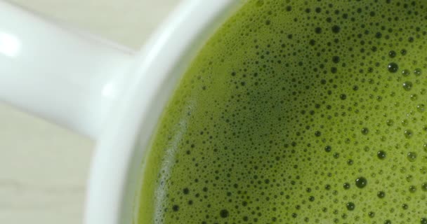 Verse matcha schuim en belletjes in witte beker, close-up — Stockvideo