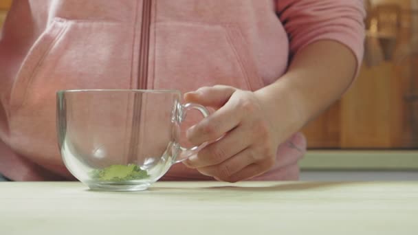 Mujer vertiendo agua caliente al polvo matcha para preparar bebida, cámara lenta — Vídeos de Stock