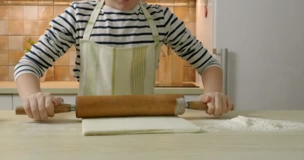 Маленький хлопчик готує тісто для прокатки на кухні — стокове відео