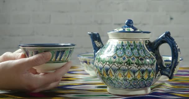 Tourist's hands and traditional uzbek teapot — 비디오