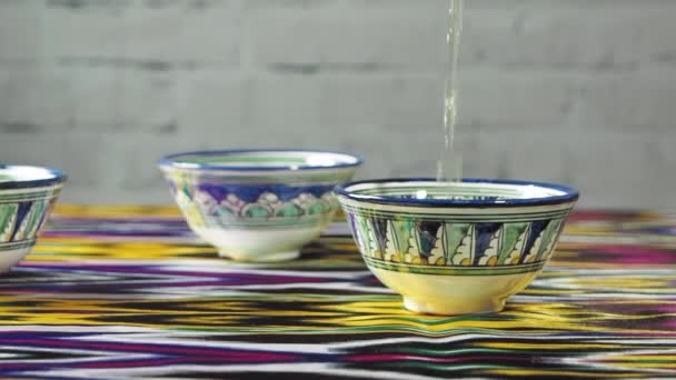 Pouring tea from traditional uzbek teapot to piala, slow motion — 비디오